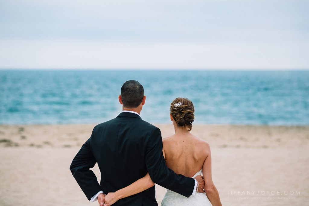 Wedding couple with arms around each other looking at water at Ocean House RI wedding