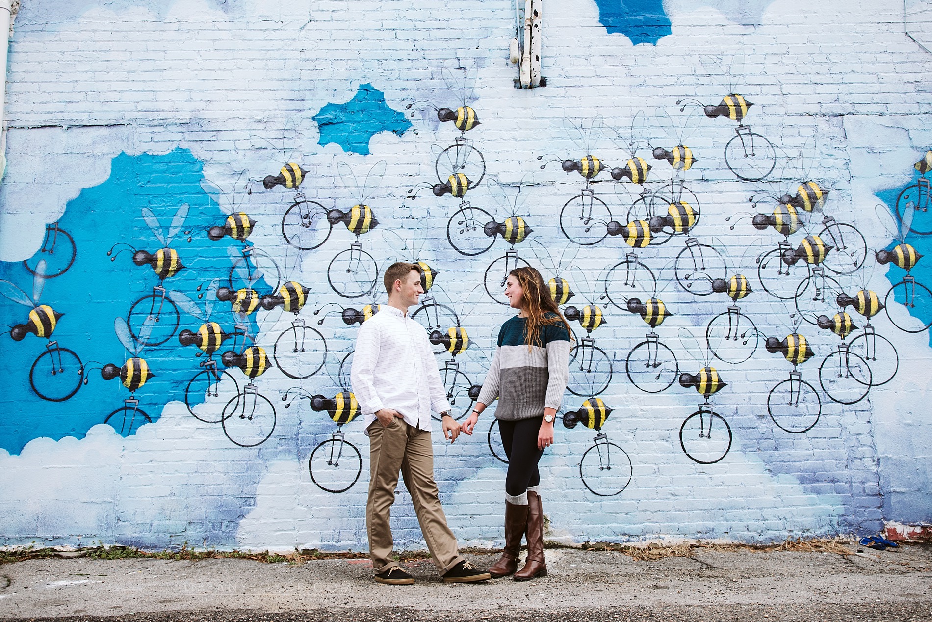 Couple holding hands in front of mural in neon district, norfolk va