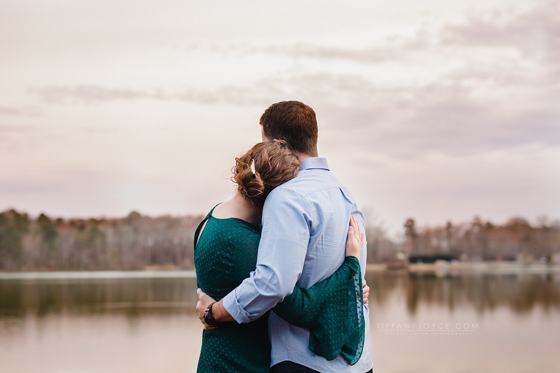 engaged couple looking out across lake at Oak Grove Lake engagement session