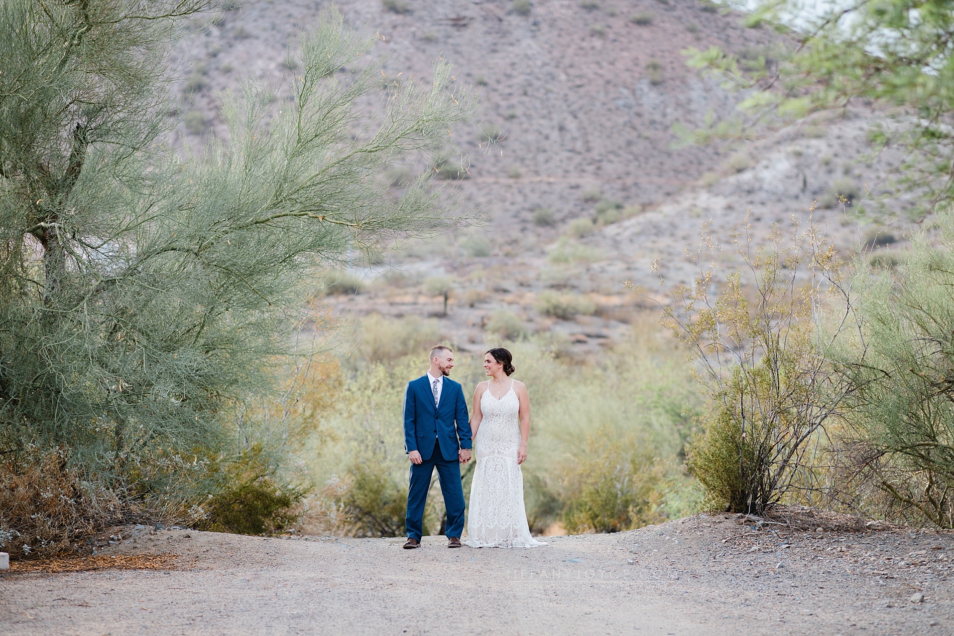 Bride and groom holding hands in desert during intimate phoenix elopement